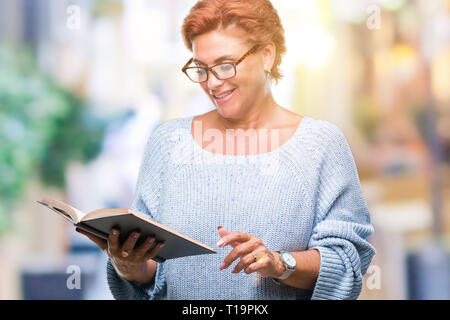 Young Woman Reading a book sur fond isolé avec un visage heureux et souriant debout avec un sourire confiant montrant les dents Banque D'Images