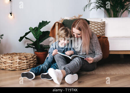 La mère et le fils en train de lire ensemble à la maison du livre Banque D'Images