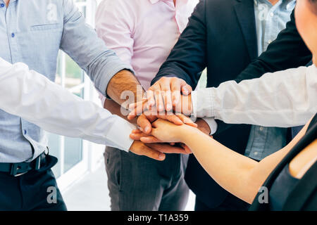 Close-up de divers hommes d'affaires de l'homme et de la femme mettant les mains ensemble - la collaboration et la solidarité dans le travail office concept Banque D'Images