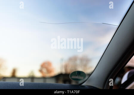 Une longue rupture du pare-brise de la voiture, de la voiture vers le centre. Ciel bleu en arrière-plan. Banque D'Images