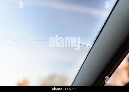 Une longue rupture du pare-brise de la voiture, de la voiture vers le centre. Ciel bleu en arrière-plan. Banque D'Images