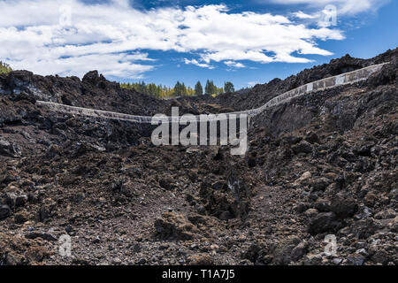 Canal d'eau en béton à travers le paysage volcanique du Chinyero prenant de l'eau pour l'irrigation à l'fincas à Santiago del Teide, Tenerife, Isla Banque D'Images