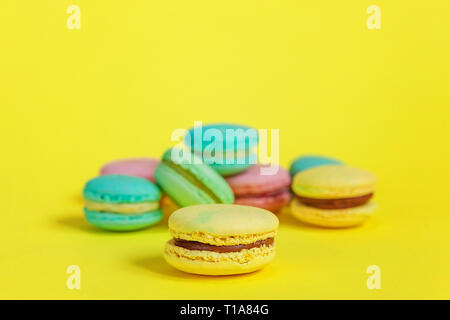 Couleur amande douce licorne rose bleu jaune vert macaron macaron ou gâteau dessert isolé sur fond jaune à la mode la mode moderne. Swee français Banque D'Images