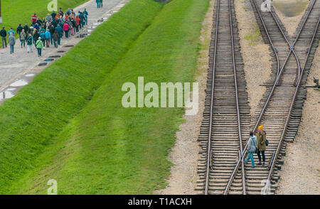 Oswiencim, Pologne - 21 septembre 2019 : Des groupes de touristes à pied le long de la ligne où les wagons sont arrivés avec les prisonniers de Birkenau. Banque D'Images