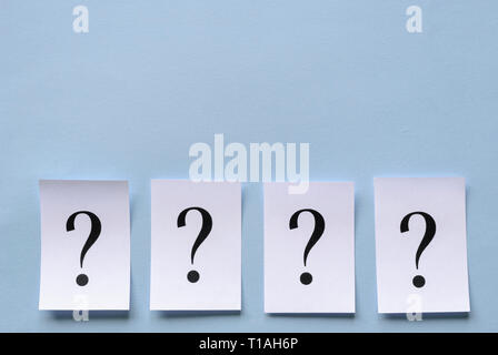 Quatre points d'interrogation imprimé sur du papier blanc formant une bordure inférieure sur fond bleu parfaitement placé dans une rangée avec ombre portée à trois dimensions et de la CDP Banque D'Images