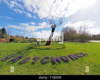 Eastchurch, Kent, UK. 25 mars, 2019. Météo France : une journée ensoleillée dans le village d'Eastchurch, Kent. Sur la photo : fleurs entourent la sculpture aviation énonçant 'Eastchurch'. La sculpture a été mis en place pour célébrer le centenaire de la fondation de l'aviation britannique sur l'île de Sheppey 1909-2009. Credit : James Bell/Alamy Live News Banque D'Images