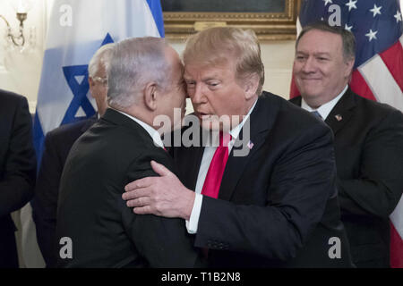 Washington, District de Columbia, Etats-Unis. Mar 25, 2019. Le premier ministre israélien Benjamin Netanyahu (L) l'embrasse la joue de nous Président Donald J. Trump (R), avant que le secrétaire d'Etat américain Mike Pompeo (R) regarde en arrière ; avant de Trump signe une ordonnance de reconnaissance des hauteurs du Golan comme territoire israélien, dans la salle de réception diplomatique de la Maison Blanche à Washington, DC, USA, le 25 mars 2019 Crédit : Michael Reynolds/CNP/ZUMA/Alamy Fil Live News Banque D'Images