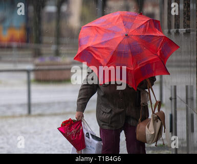 Brandenburg an der Havel, Allemagne. Mar 25, 2019. Une femme avec un parapluie dans une tempête de grêle. Credit : Monika Skolimowska/dpa-Zentralbild/dpa/Alamy Live News Banque D'Images