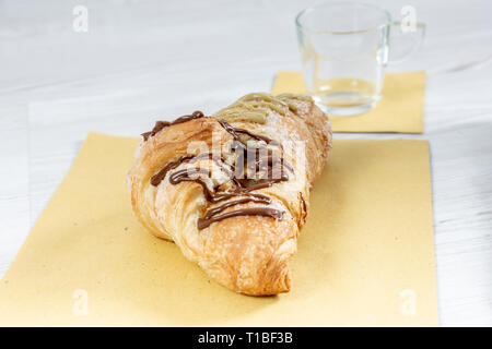 Brioche gourmande avec du chocolat et farci à la pistache sur une table en bois Banque D'Images