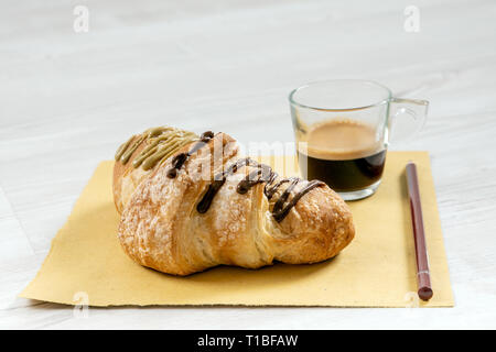 Brioche gourmande avec du chocolat et farci à la pistache sur une table en bois Banque D'Images