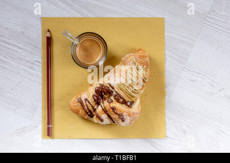 Brioche gourmande avec du chocolat et farci à la pistache sur une table en bois Banque D'Images