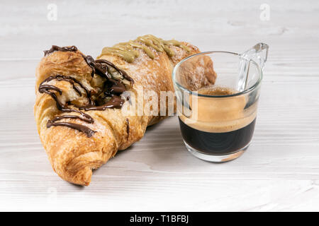 Brioche gourmande avec du chocolat et farci à la pistache sur une table en bois Banque D'Images