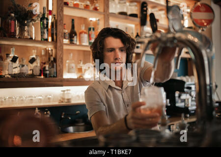 Barman préparer boissons derrière un comptoir bar de nuit Banque D'Images