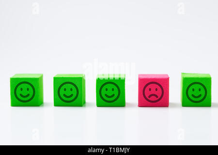 Seul visage triste parmi les visages de sourire heureux Banque D'Images