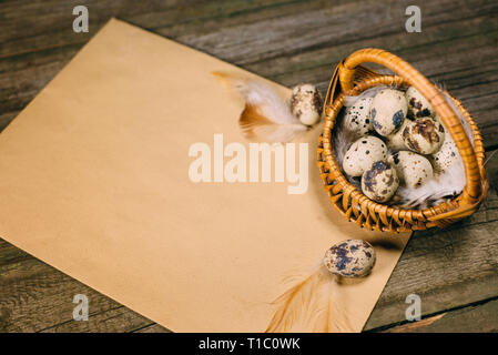 Vieux papier avec des oeufs de cailles à l'intérieur du petit panier de bois rustique. Eastering ou la chasse vintage background Banque D'Images