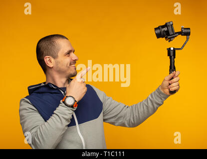 L'homme video blogger pointant dans l'appareil photo et à tout bout de tournage Banque D'Images