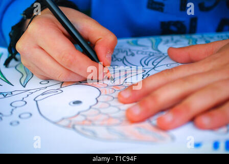 Boy painting scrap book, image d'un Banque D'Images