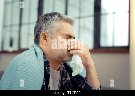 Triste homme malade à l'aide d'un mouchoir en papier Banque D'Images