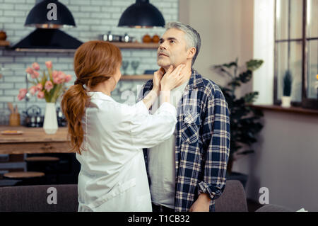 Femme médecin professionnel patients touchant son cou Banque D'Images