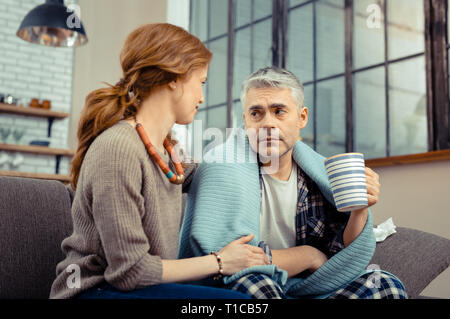 Belle femme bienveillante qui appuient sa mauvais mari Banque D'Images