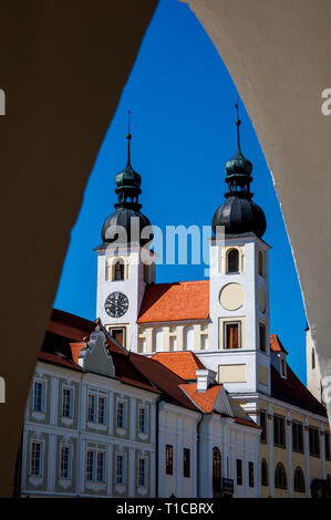 Vue de l'église Baroque du saint Nom de Jésus à Telc encadrée par arcade , région de Vysocina, République Tchèque Banque D'Images