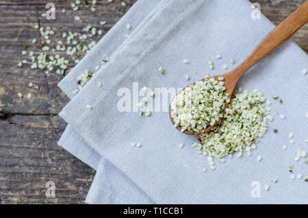 Blanchis, les graines de chanvre biologique dans une cuillère sur la table en bois rustique. Supplément de la saine alimentation. Superfood concept. Banque D'Images