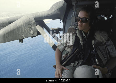 29 octobre 1993 une femme soldat de l'armée américaine se trouve à la porte ouverte d'une armée américaine Sikorsky UH-60 Black Hawk comme il vole au dessus de l'Océan Indien à la sortie de Mogadiscio, en Somalie. Banque D'Images