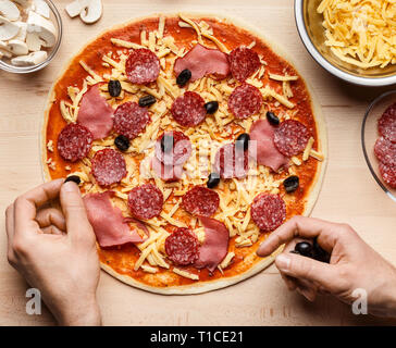 La décoration de l'homme italien pizza aux olives noires Banque D'Images