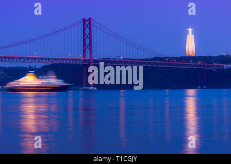 Bateau de croisière en passant sous le pont du 25 avril et d'Almada Cristo Rei statue au coucher du soleil, le quartier de Belém, Lisbonne, Portugal Banque D'Images