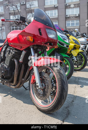 Rouge vert et jaune en moto parking en ligne close up Banque D'Images