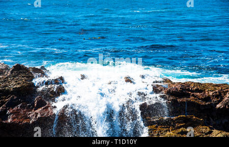 Blue ocean vagues se brisant contre les rochers et les lave sur les rochers. Banque D'Images