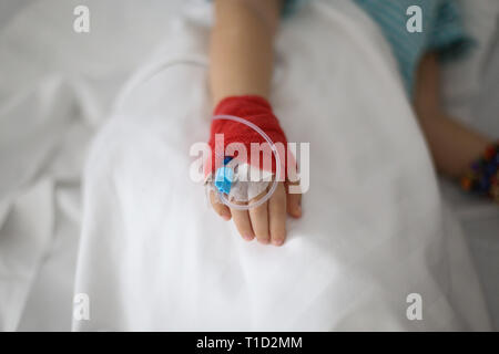 Avec l'aide d'une canule sur la main d'une petite fille malade dans un hôpital pédiatrique réserver Banque D'Images