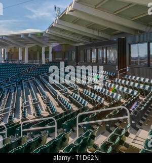 Des chaises et des chambres à un stade contre le ciel bleu. Chaises vert vide à un stade avec ciel bleu dans le ciel d'une journée ensoleillée. Chambres avec fenêtres réfléchissantes c Banque D'Images