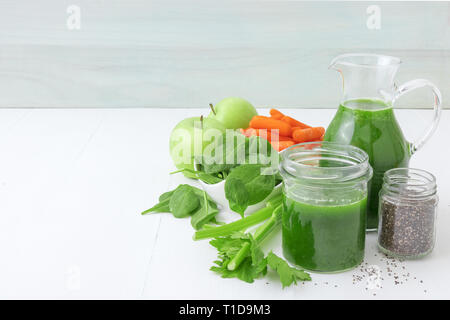 Smoothie de légumes biologiques sains, fabriqués à partir de jus de céleri, pomme verte, les feuilles d'épinards et les jeunes carottes. Grand pichet et pot de jus vert, petite Banque D'Images