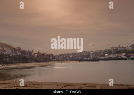 Whitby Harbour Town et à l'intérieur. Les bâtiments de la ville vers le haut de la pile à côté de la voie d'eau et de la plage de sable conduit à bord de l'eau. Une cl Banque D'Images