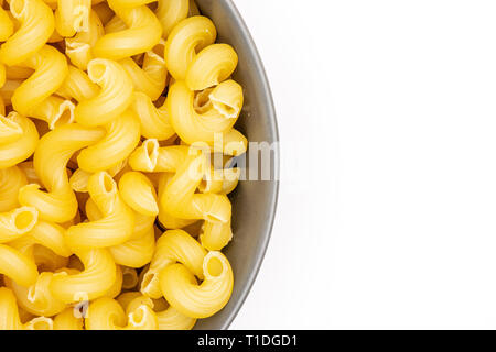 Beaucoup de gros plan pâtes cavatappi entier dans un bol en céramique gris flatlay isolé sur fond blanc Banque D'Images