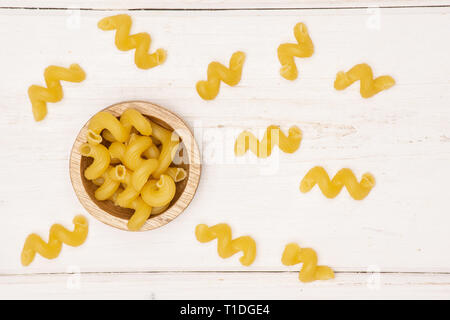 Beaucoup de pâtes cavatappi entier avec bol en bois bois blanc sur flatlay Banque D'Images