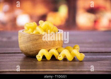 Lot de pâtes crues cavatappi avec bol en bois dans une cuisine rustique en bois Banque D'Images