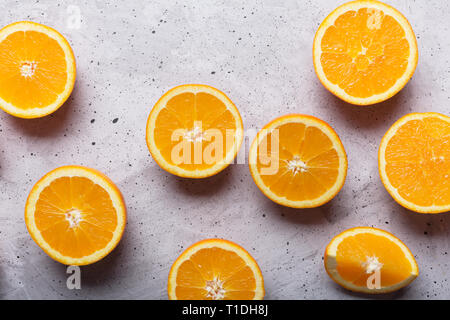 Les oranges en tranches sur un fond gris, vue du dessus. Ce fruit est une source de vitamines et de matières premières pour faire des jus de fruits Banque D'Images