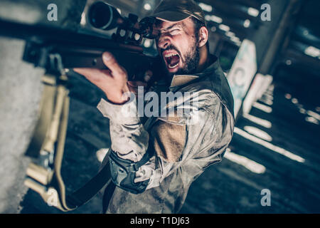 Soldat est crème. Il est à la recherche d'objectif intermédiaire parce qu'il prend fin. Guy est redady à tirer de la carabine. Banque D'Images