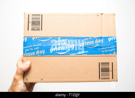 Paris, France - 11 juil 2018 : Man hand holding contre fond blanc scellé avec du ruban adhésif spécial d'Amazone la livraison de colis Banque D'Images