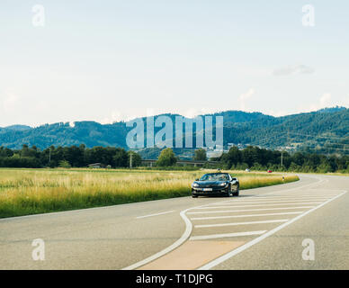 Schiltach, Allemagne - Jun 10, 2018 : l'autoroute allemande de luxe avec voiture cabriolet Chevrolet Corvette décapotable conduite rapide sur la route de campagne sur une journée ensoleillée avec des montagnes en arrière-plan de la Forêt-Noire Banque D'Images