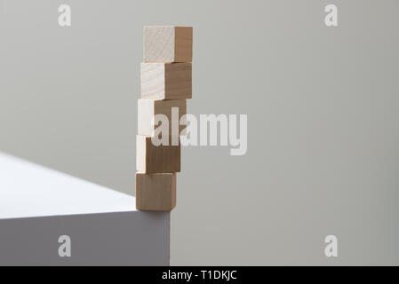 Cubes en bois en équilibre au bord de la table pour la notion de risque Banque D'Images