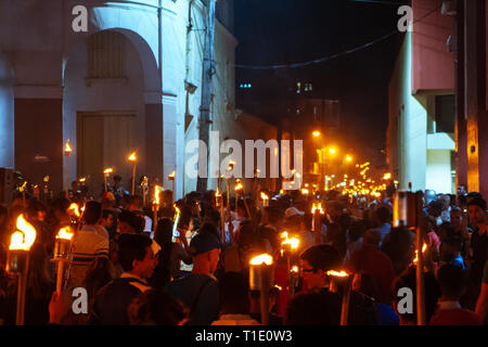 Santa Clara, Cuba - 27 janvier 2019 : Des milliers de personnes marchant dans la rue, tenant dans leurs mains des flambeaux allumés la nuit Banque D'Images