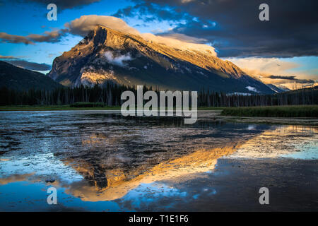 Le mont Rundle reflétée dans les lacs Vermillion comme les nuages de tempête brosse le sommet de la montagne. Banque D'Images