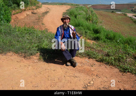 Homme mature local fumant une pipe à un petit village dans les montagnes près de Kumming, province du Yunnan dans le sud-ouest de la Chine en septembre Banque D'Images