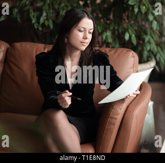 Close up. business woman sitting dans le centre d'affaires et la lecture de documents Banque D'Images
