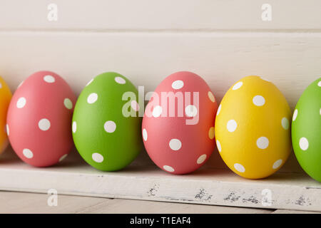 Peindre les oeufs de Pâques colorés avec des points d'affilée sur planches en bois blanc, concept de vacances Banque D'Images