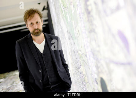 Berlin, Allemagne. Mar 25, 2019. Andreas Engwert, directeur de l'exposition 'Stasi à Berlin - La surveillance et la répression dans l'Est et l'Ouest', est debout sur une photographie aérienne de Berlin, où le cours du mur et les lieux liés à la Stasi sont marqués. L'exposition montrera l'infrastructure cachés de la Stasi et sera ouverte le 28.03.2019 dans l'Hohenschönhausen Memorial. (Pour dpa 'Nouvelle exposition : les réunions de la Stasi, Photo aérienne, des comprimés) Credit : Britta Pedersen/dpa-Zentralbild/dpa/Alamy Live News Banque D'Images