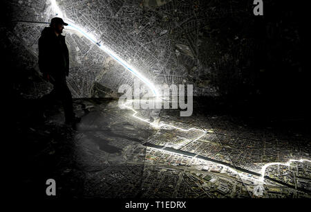 Berlin, Allemagne. Mar 25, 2019. Un jeune homme marche sur une photo aérienne de Berlin, marquant le tracé du mur et des lieux qui avait à voir avec la Stasi. Le spectacle avec le titre 'Stasi à Berlin - La surveillance et la répression dans l'Est et l'Ouest' affiche l'infrastructure cachés de la Stasi et sera ouverte le 28 mars 2019 dans la Hohenschönhausen Memorial. (Pour dpa 'Nouvelle exposition : les réunions de la Stasi, Photo aérienne, des comprimés) Credit : Britta Pedersen/dpa-Zentralbild/dpa/Alamy Live News Banque D'Images